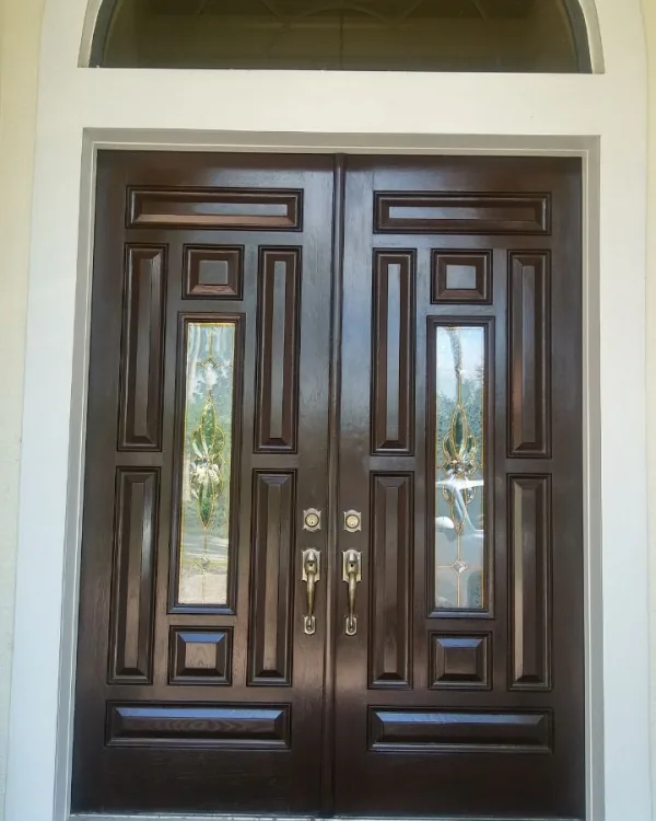 Dark-stained double entry doors with leaded glass panels, refinished on-site